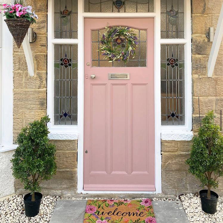 Customer photo (@oscadahome) featuring an artificial wreath and potted trees