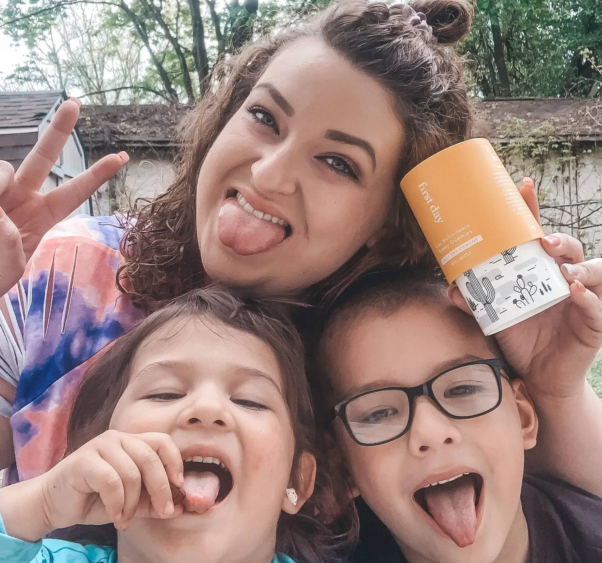 Image of two kids with their mom being silly with their tongues out.