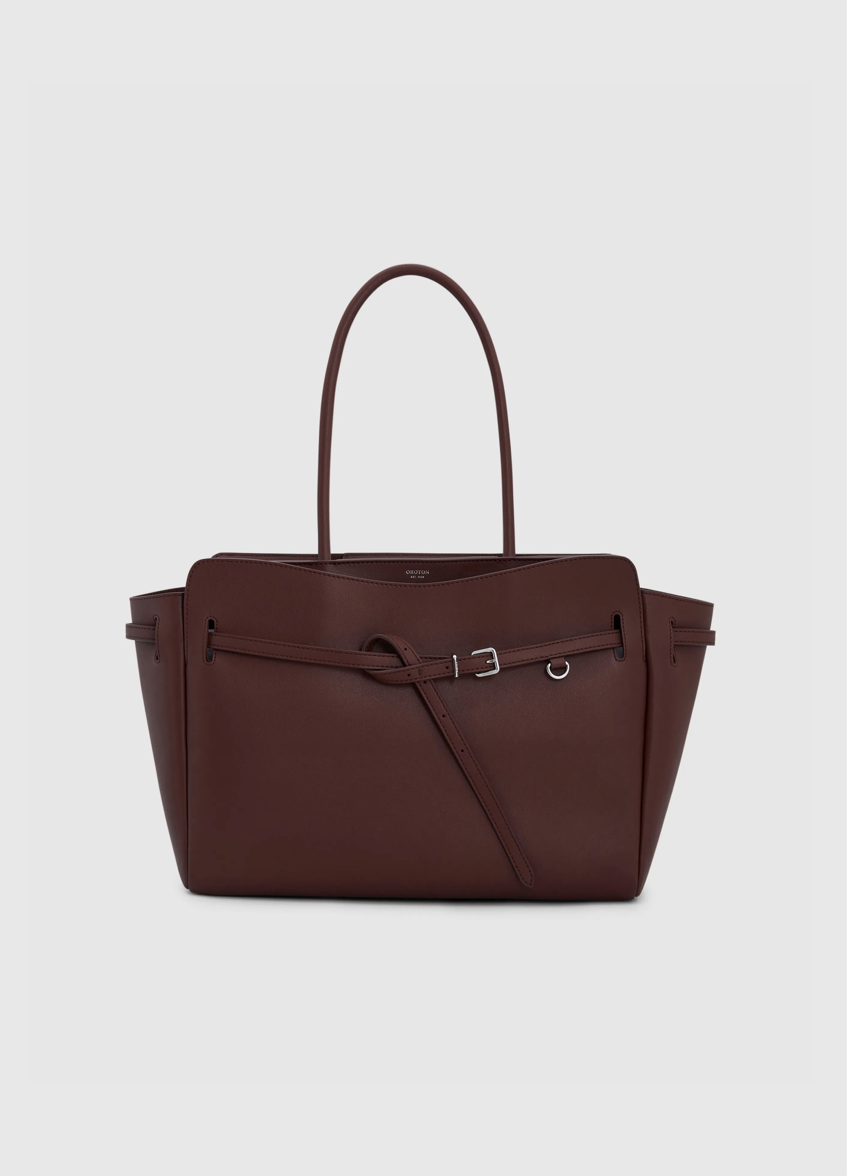 Brown leather handbag with long handles and a front zipper detail.