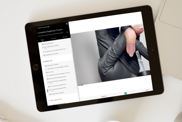 A close-up of a hand wearing a black glove on a tablet screen.
