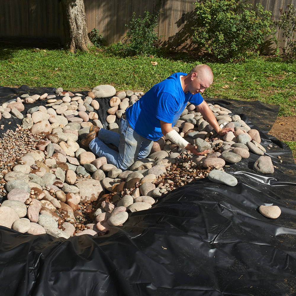 Cover the pond liner with landscaping rock 