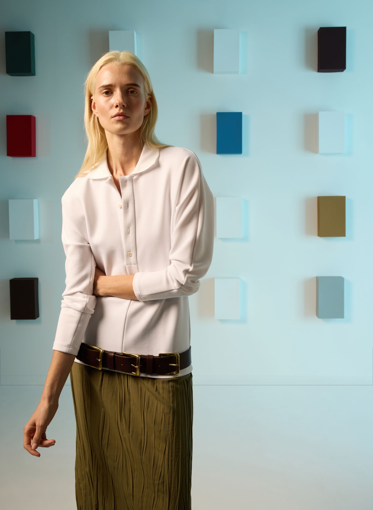 Model in stylish outfit posing against a colorful backdrop.