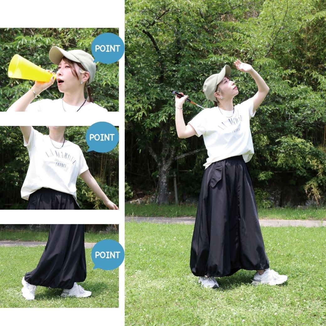 Person in a park wearing a cap, shirt, and long skirt, celebrating joyfully.