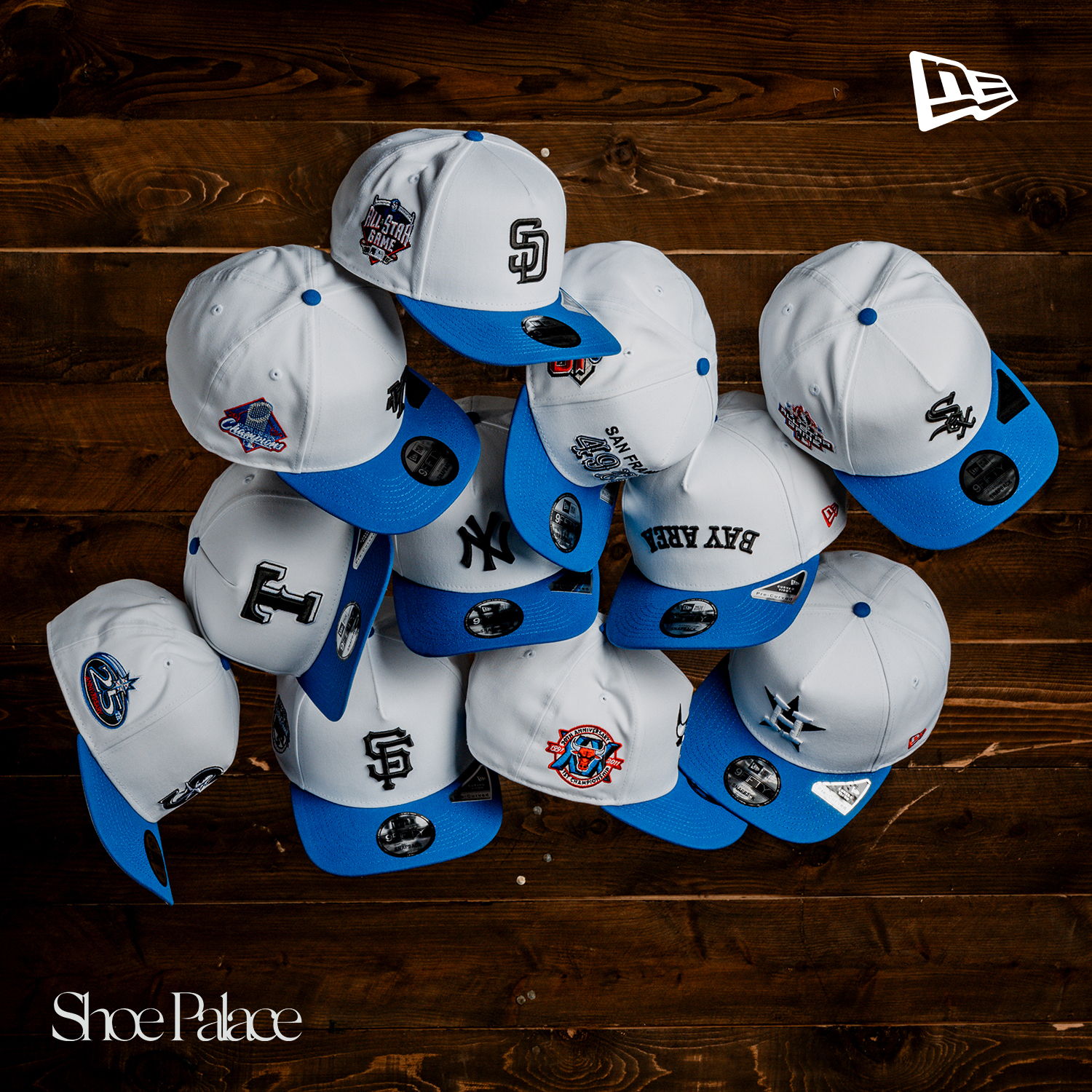 A collection of baseball caps arranged on a wooden surface.