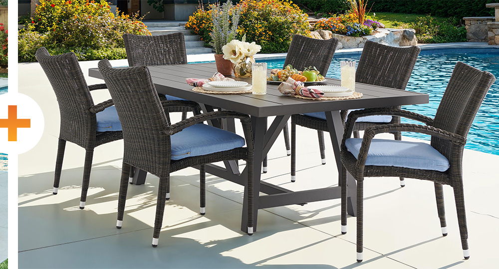 Outdoor dining set by a pool with chairs and a table.