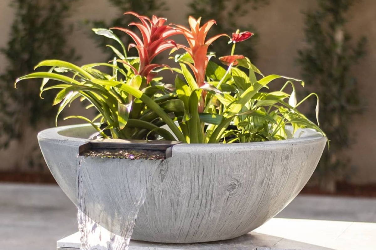 A round shaped planter and water bowl that has a wood grain concrete finish.