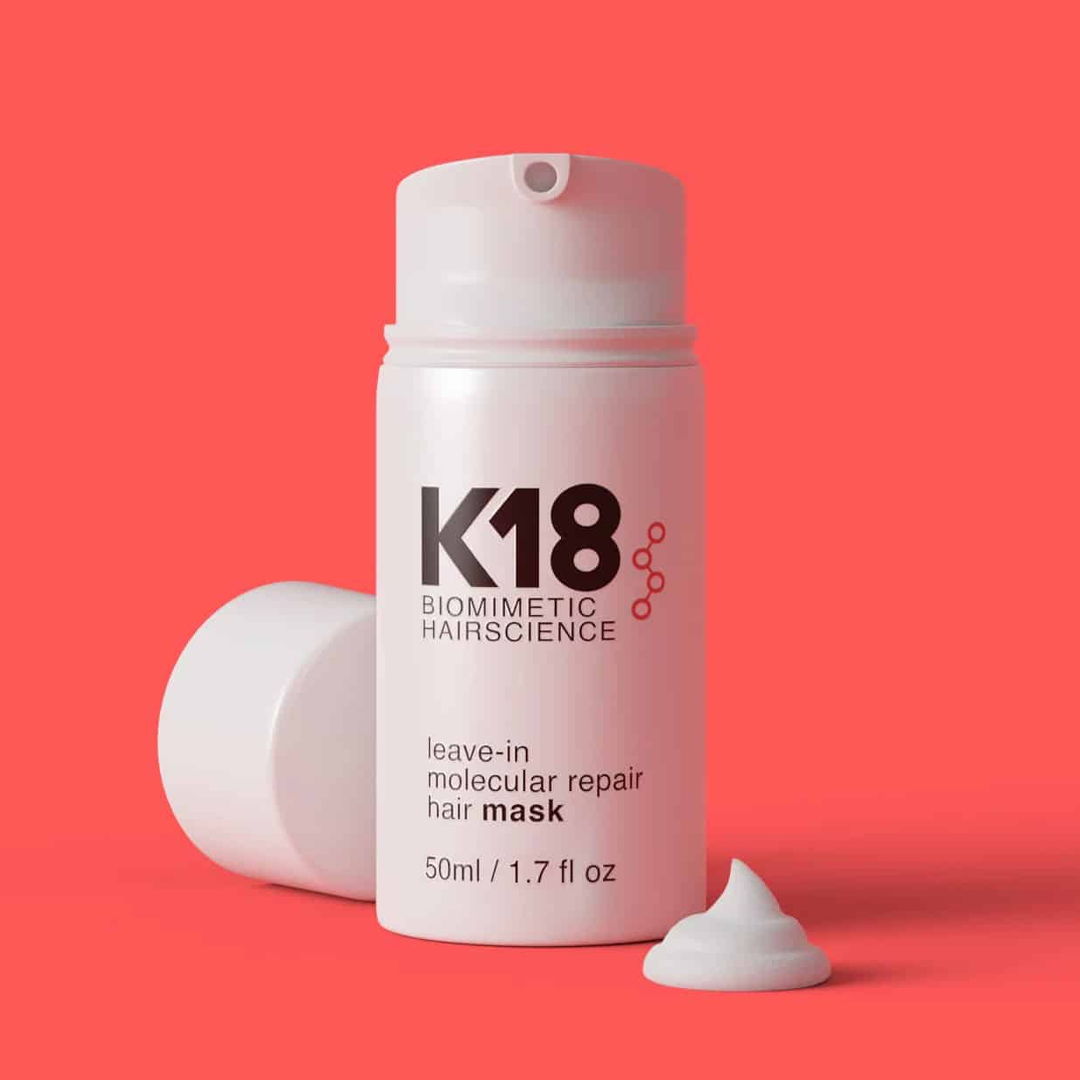 K18 leave-in molecular repair hair mask bottle on a red background.