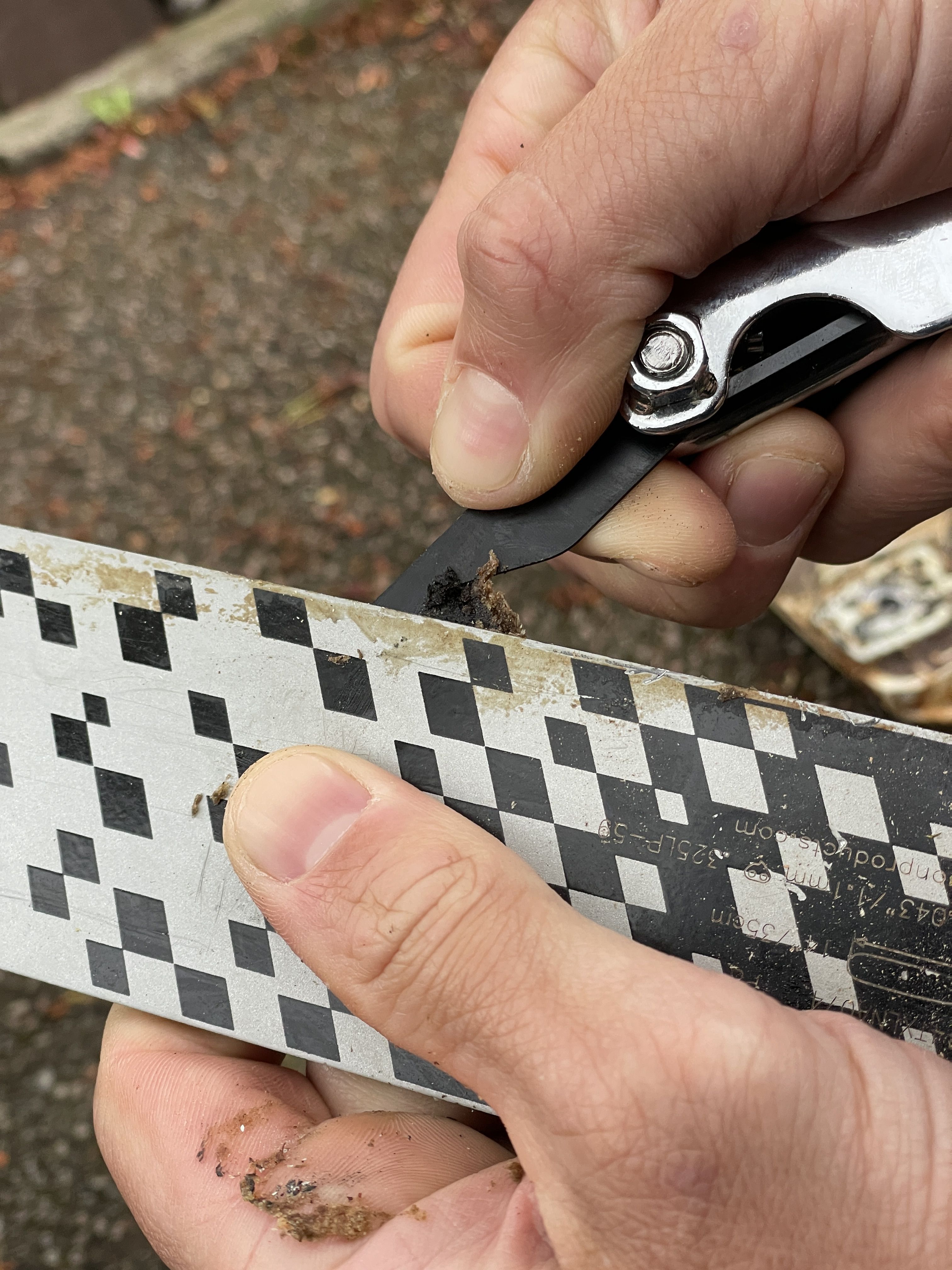 Person using a tool to scrape a patterned surface.