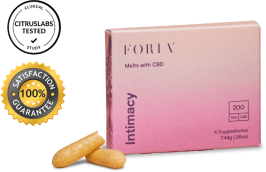 One box of Foria Intimacy Melts with pink packaging design, angled to the right a bit, and two loose melts resting against the box.