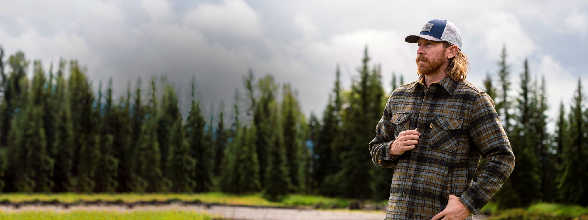 Man wearing a Buffalo Jackson plaid brushed-wool shirt jac in a pine forest