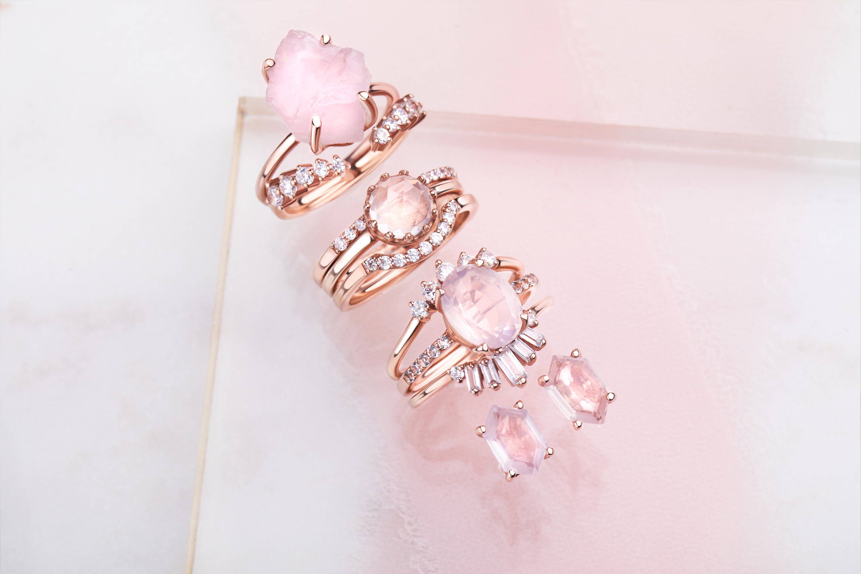 A collection of different Rose Quartz Rings, Stackable Rings and a pair of Rose Quartz Earrings.