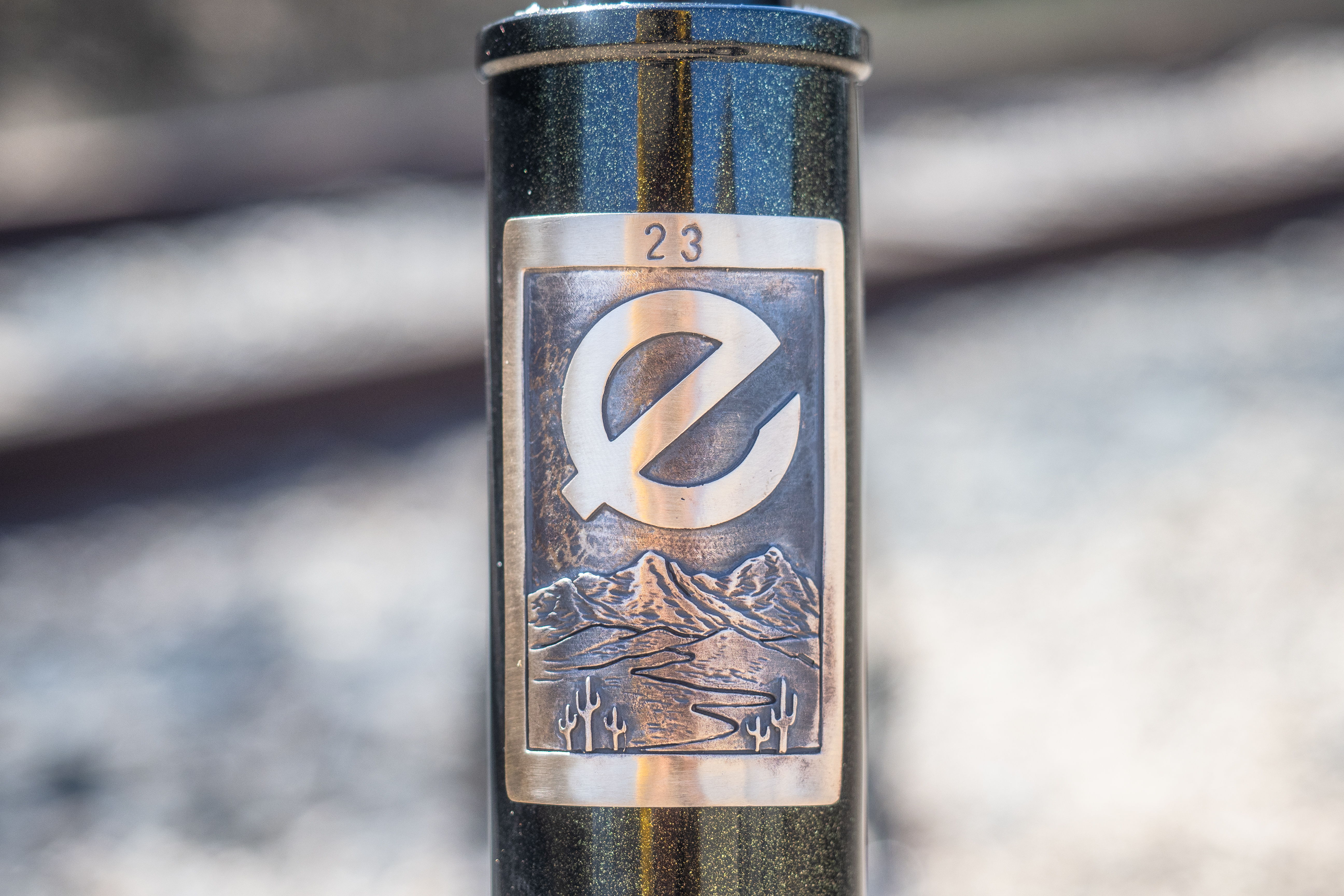 A cylindrical object with an illustrated label featuring the letter 