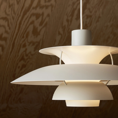 Modern pendant lamp with layered white shades against a wooden background.