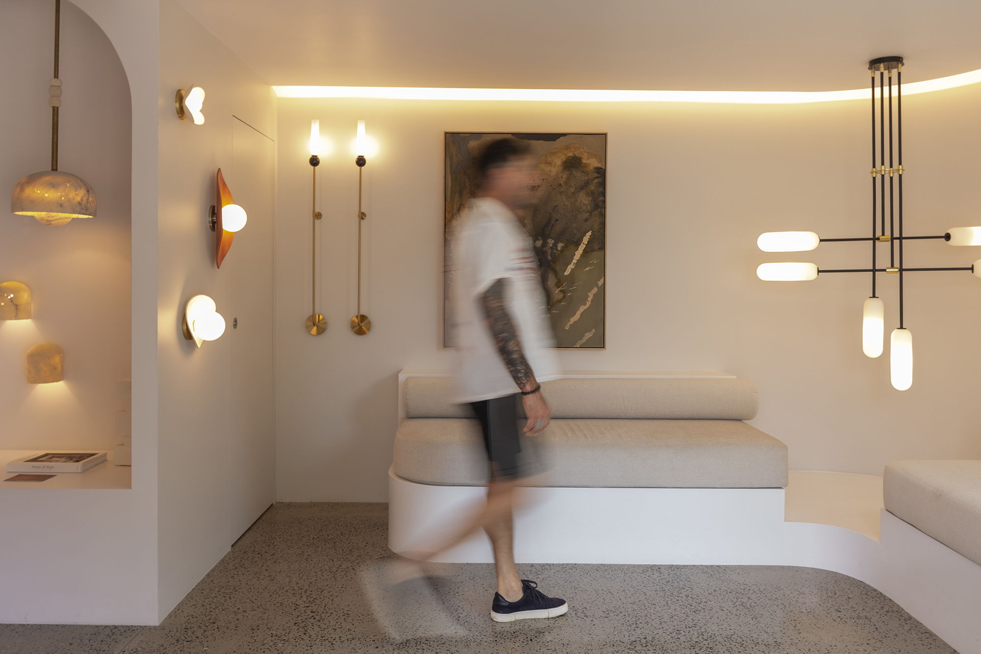 Stephen Skinner walks through a modern, well-lit interior space with decorative lighting.