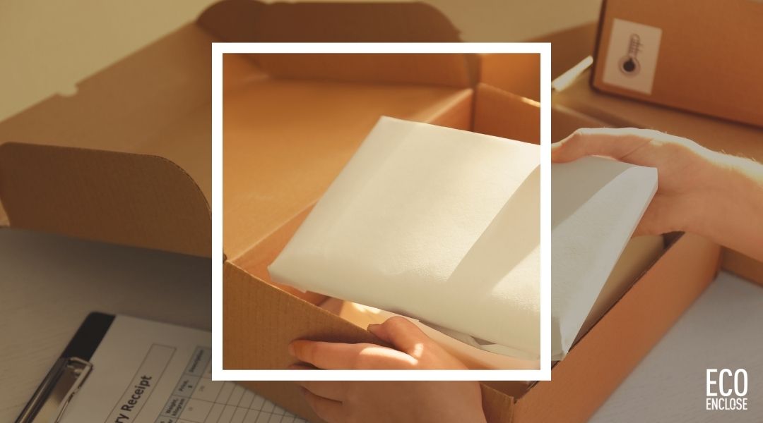 A person placing a white item into an open cardboard box.