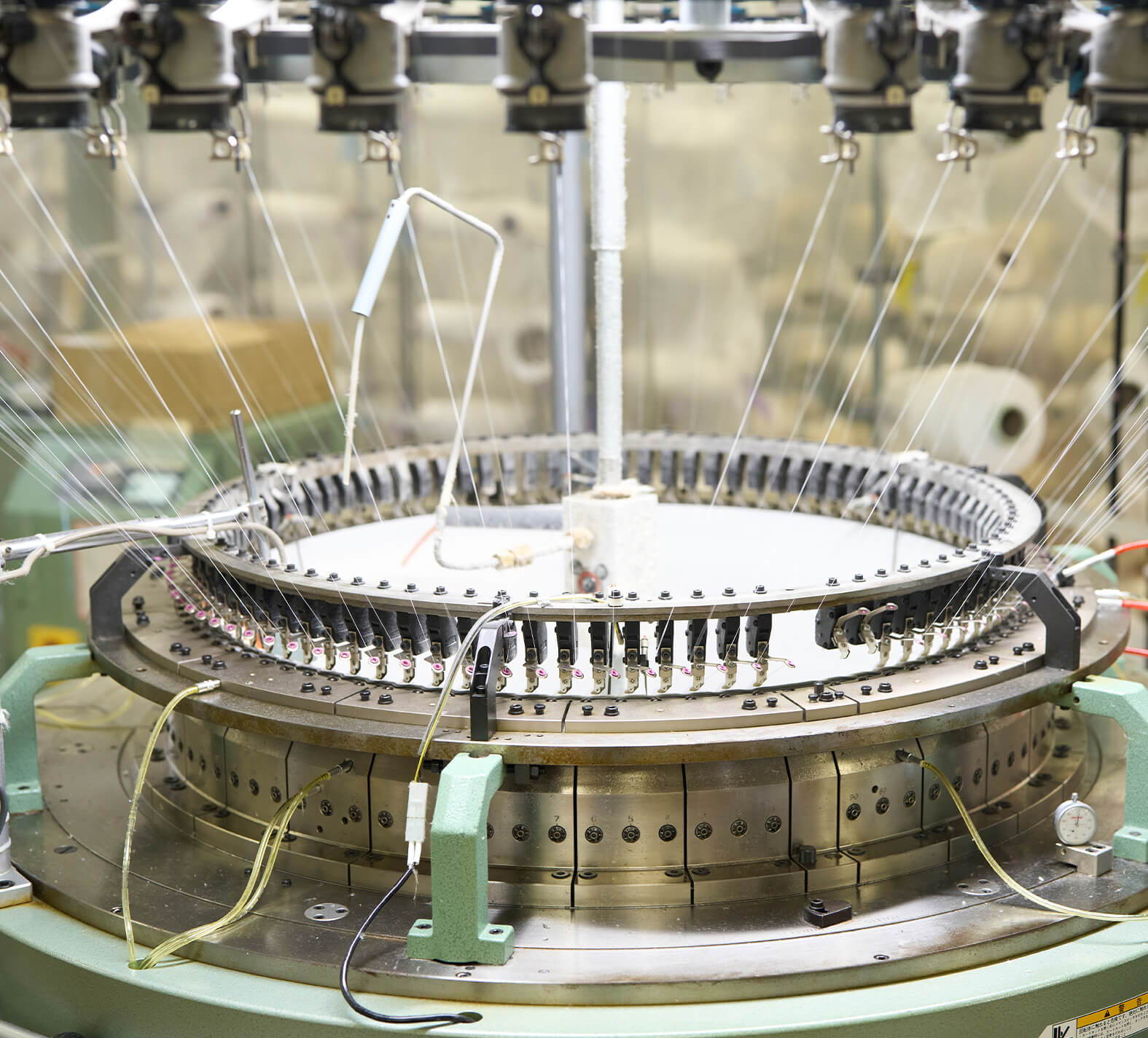 Industrial machinery with multiple tubes and a rotating platform in a production setting.