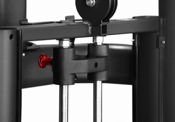 Close-up of a gym weight machine with pulleys and a red adjustment knob.