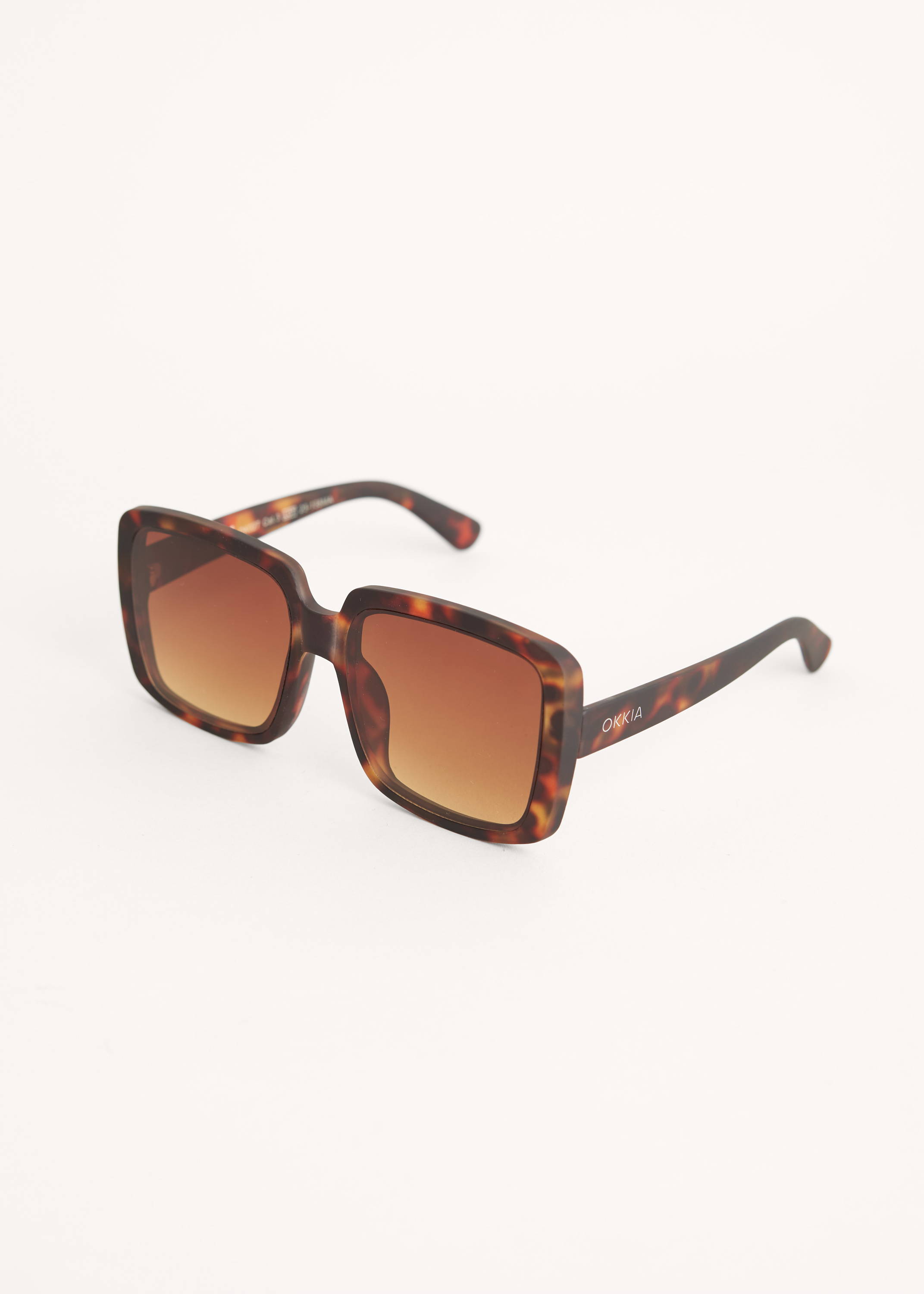 A pair of rectangular tortoiseshell 70s style sunglasses with brown lenses