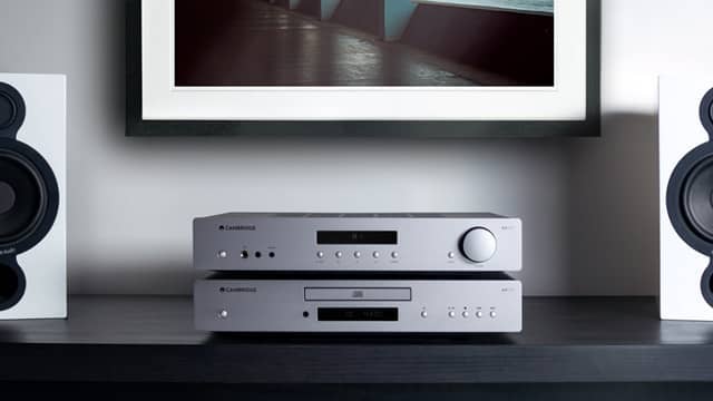 Audio equipment with speakers and a framed picture on the wall.