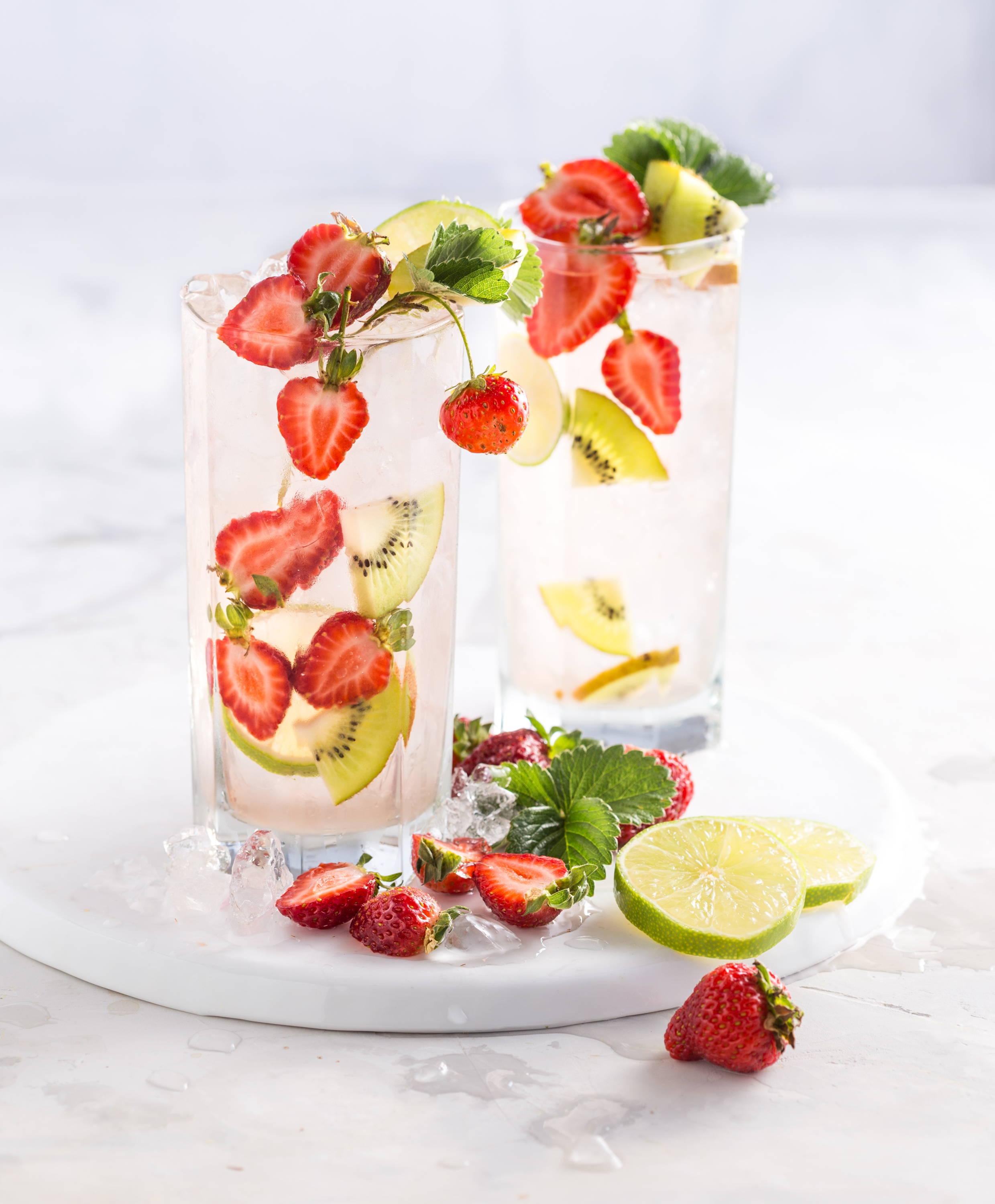 A glass of alkaline water infused with kiwis and strawberries