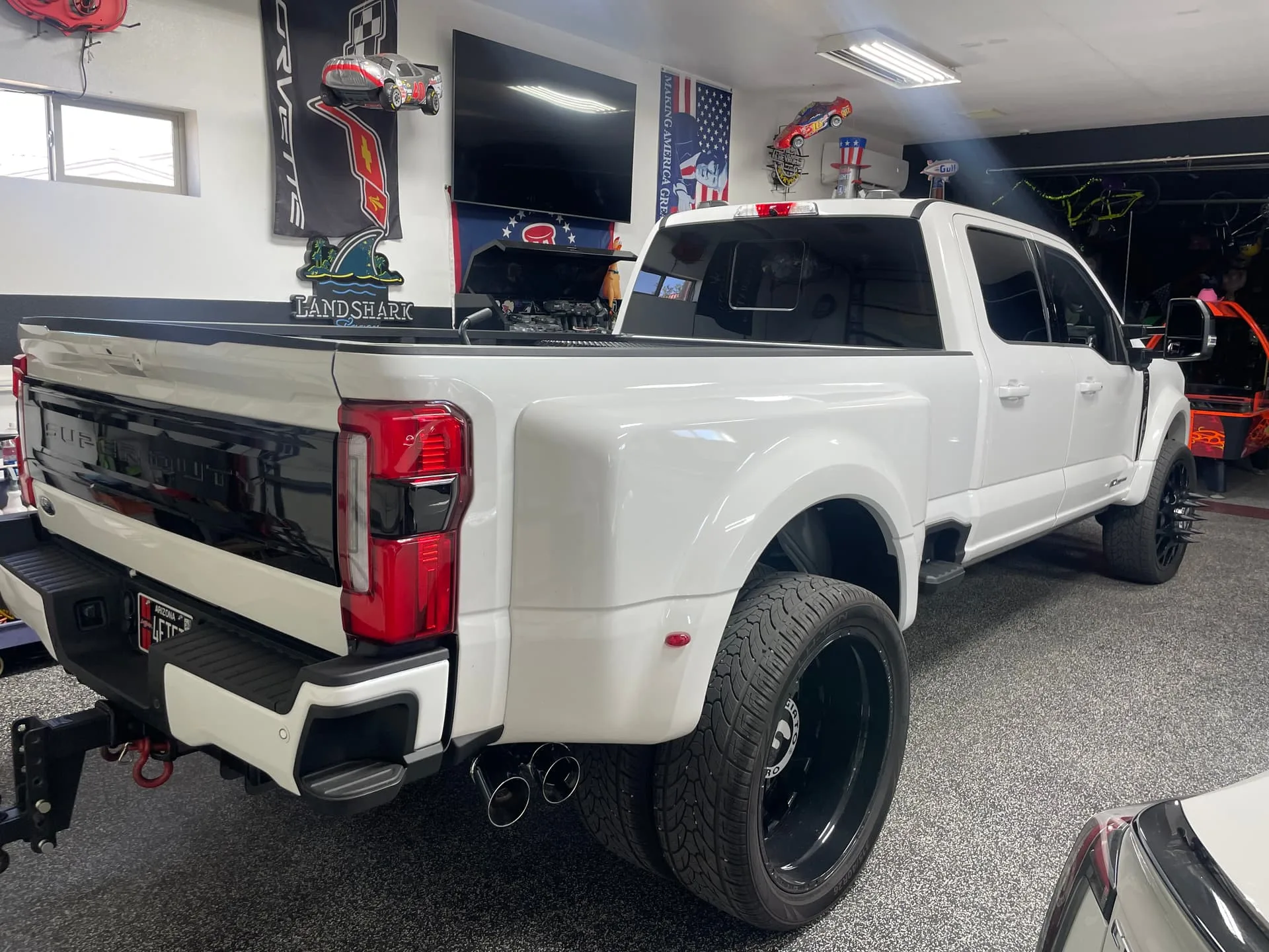 Rear three-quarter Robert's white Ford F450 Super Duty dually with drop hitch in garage photo 14