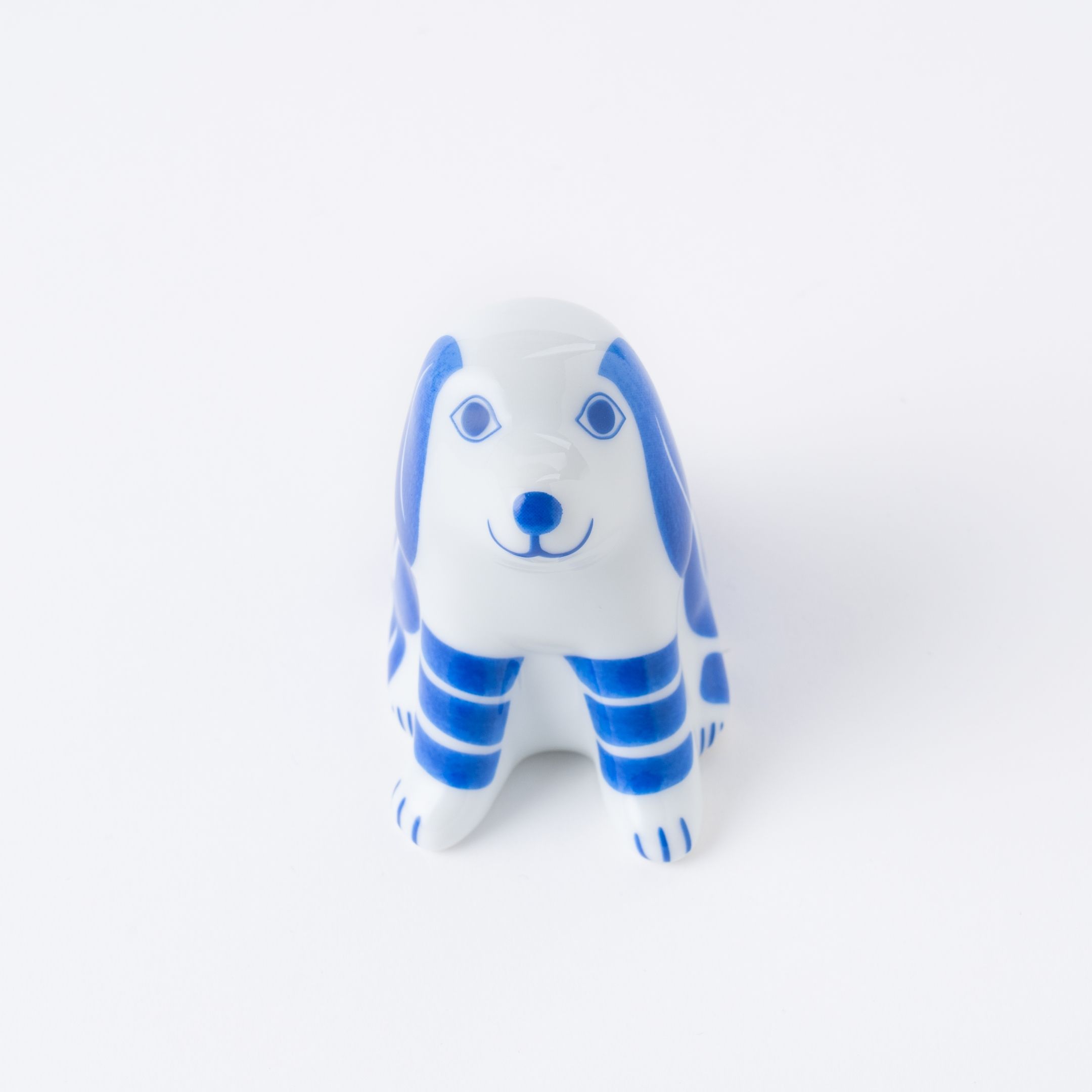A ceramic figurine of a blue and white dog.