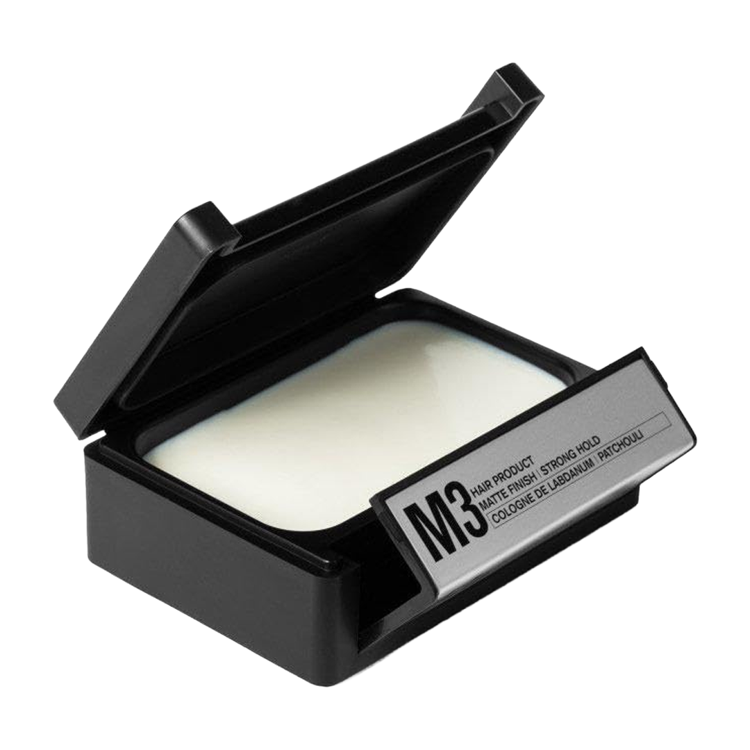 Black container with a white cream or lotion inside.