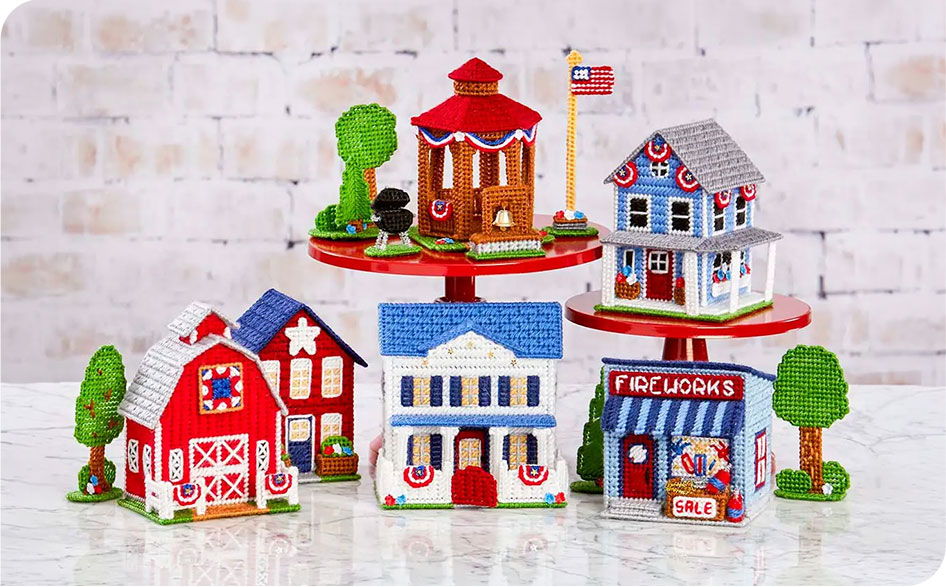 Patriotic miniature houses arranged on a display with trees and flags.