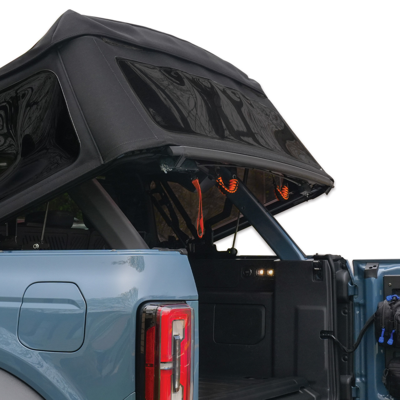 A truck with a partially opened soft top cover.