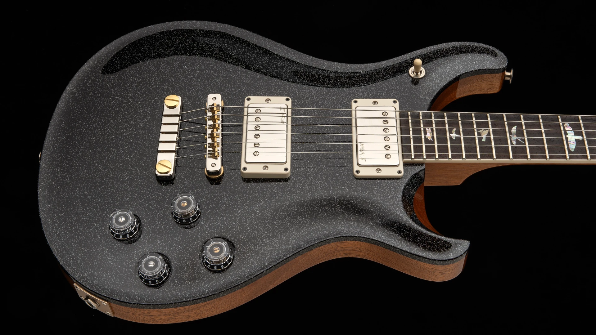 Black PRS McCarty 594 electric guitar with gold hardware and control knobs on the body.