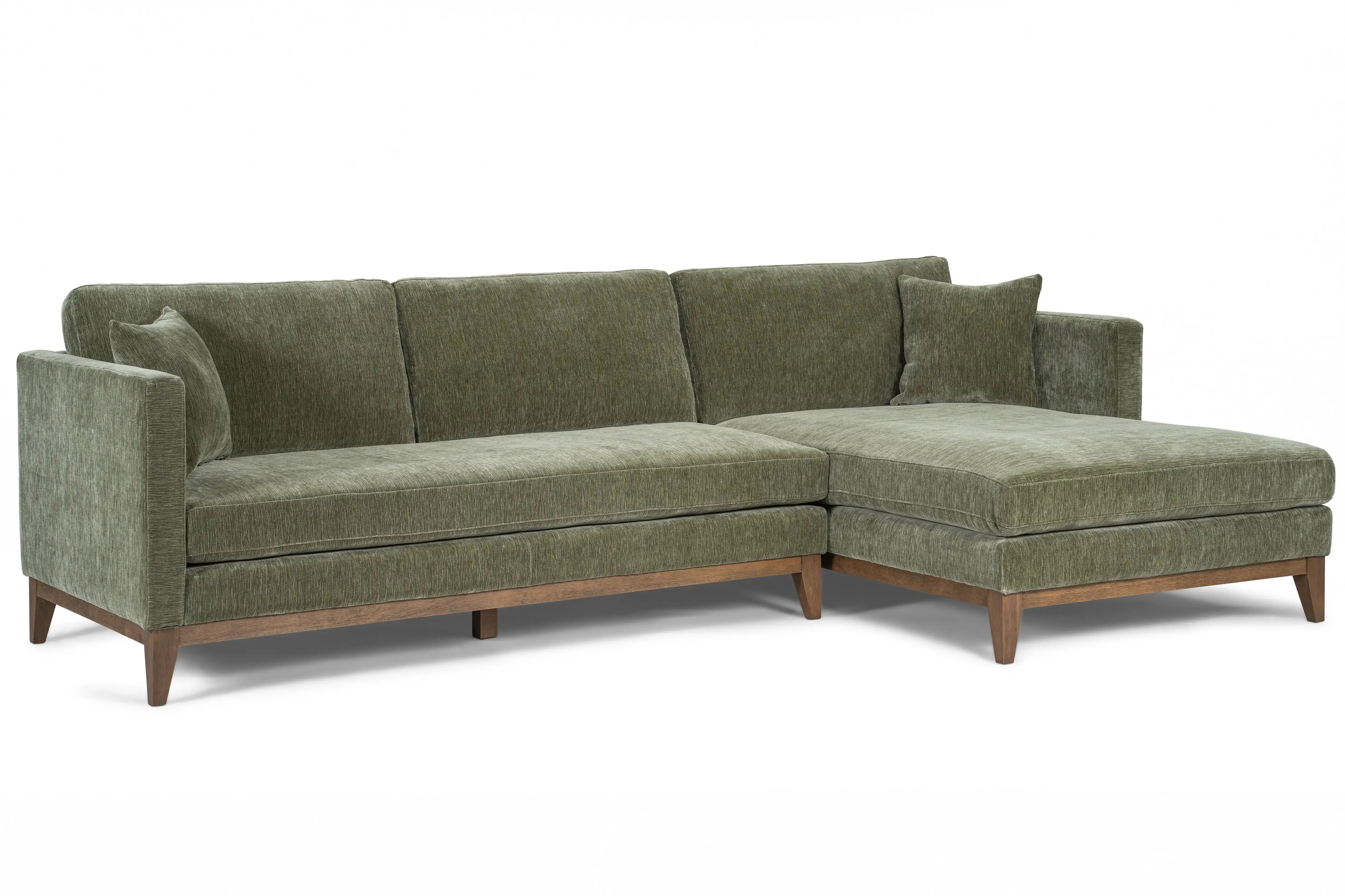 Green sectional sofa with wooden legs and cushions.