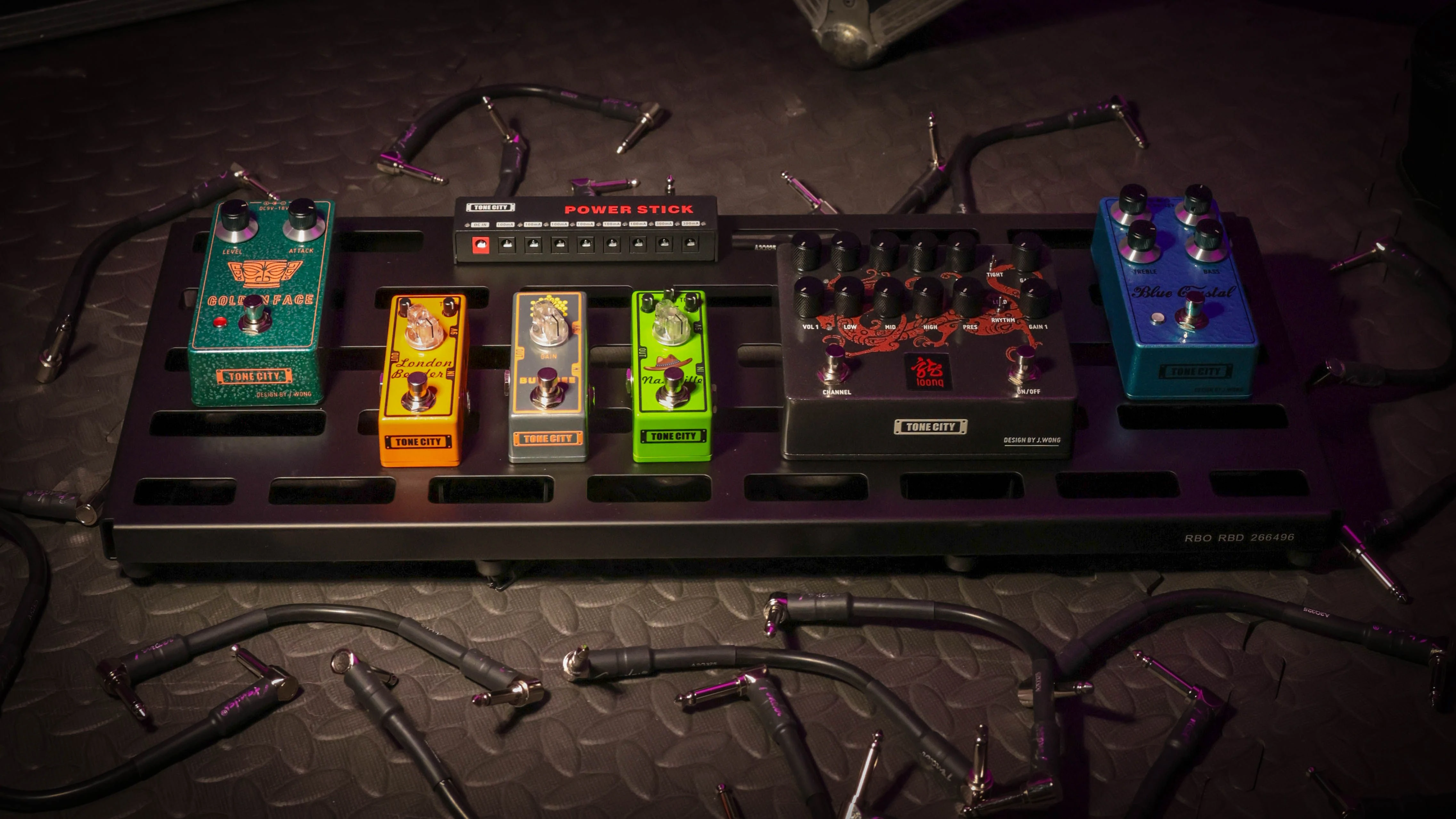 A guitar effects pedalboard with various colorful pedals and cables.