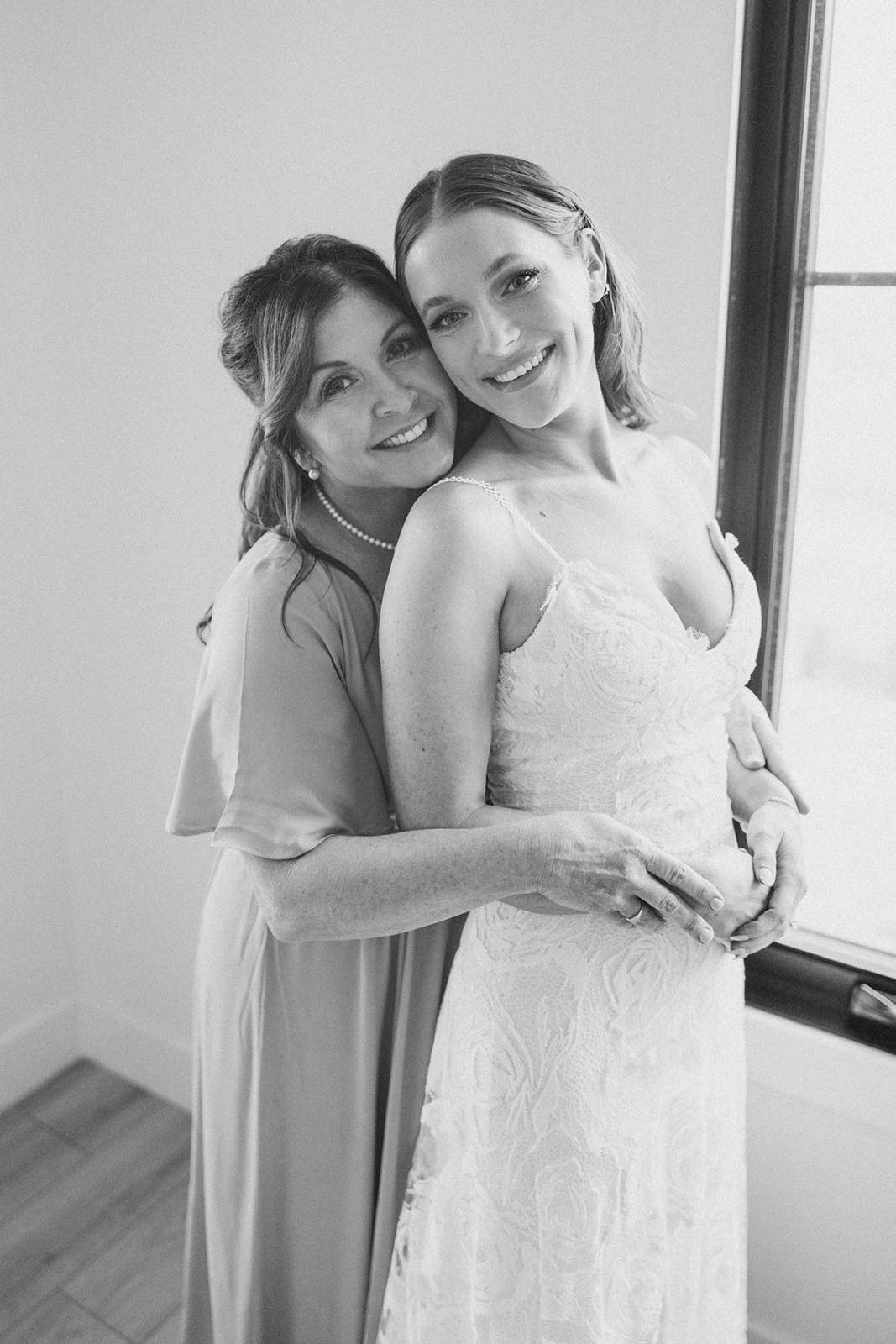 Bride, alongside her mother who caresses her baby bump