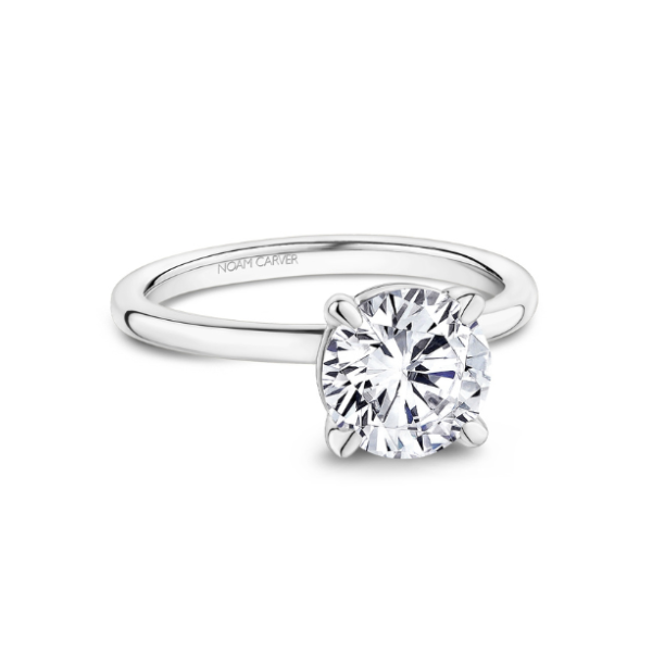 Solitaire engagement ring with a round diamond on a simple silver band.