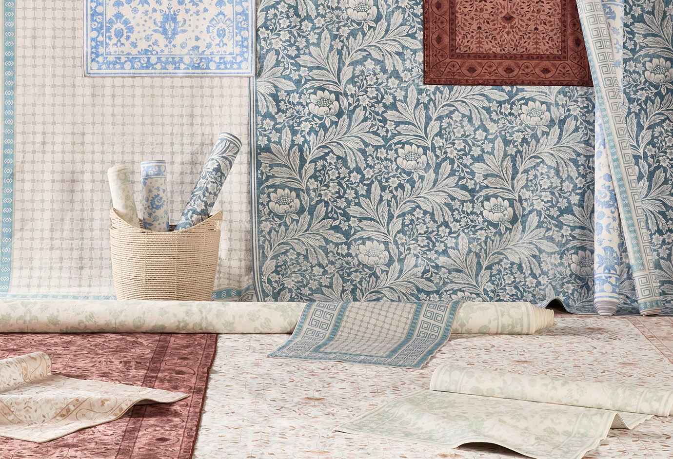 Various patterned fabrics arranged with a basket and rolled materials.