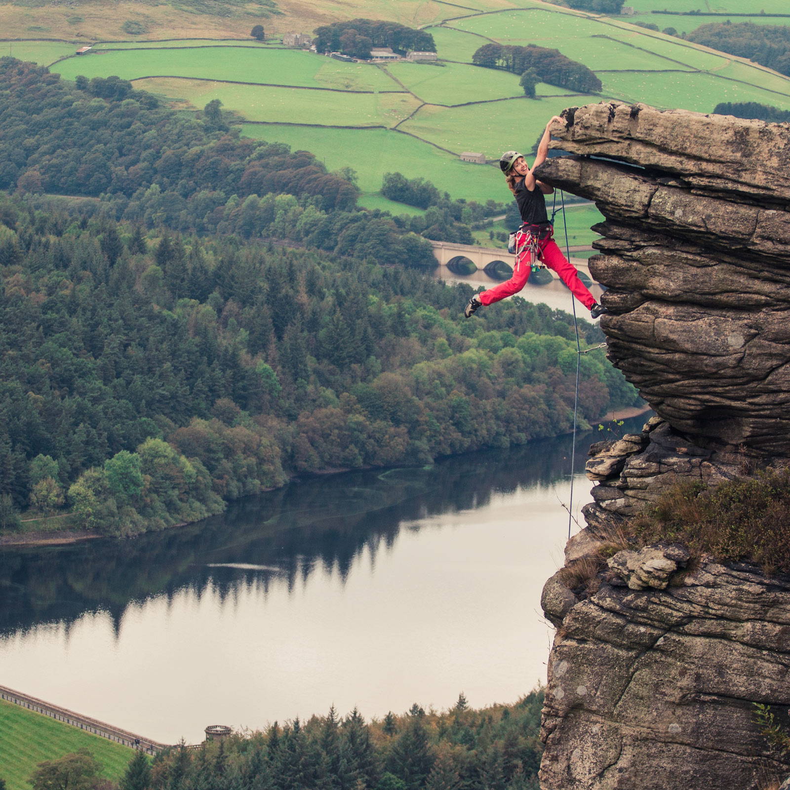 An image of Jess casually hanging off the top of a route at Bamford edge called Gargoyle Edge