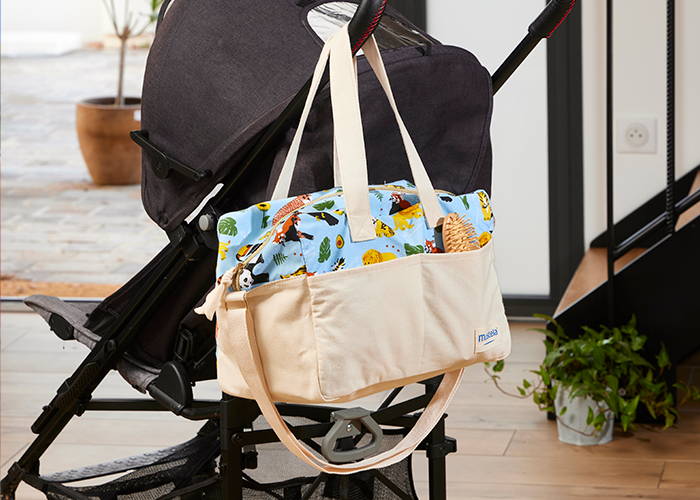 Canastilla bebé de Mustela que también sirve como bolsa de paseo colgando de un carro de bebé