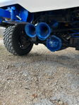 Rear underbody view of blue HornBlasters train horns with matching blue suspension and ghost-logo differential cover