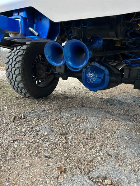 Rear underbody view of blue HornBlasters train horns with matching blue suspension and ghost-logo differential cover