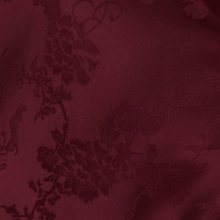 Burgundy fabric with floral pattern texture.