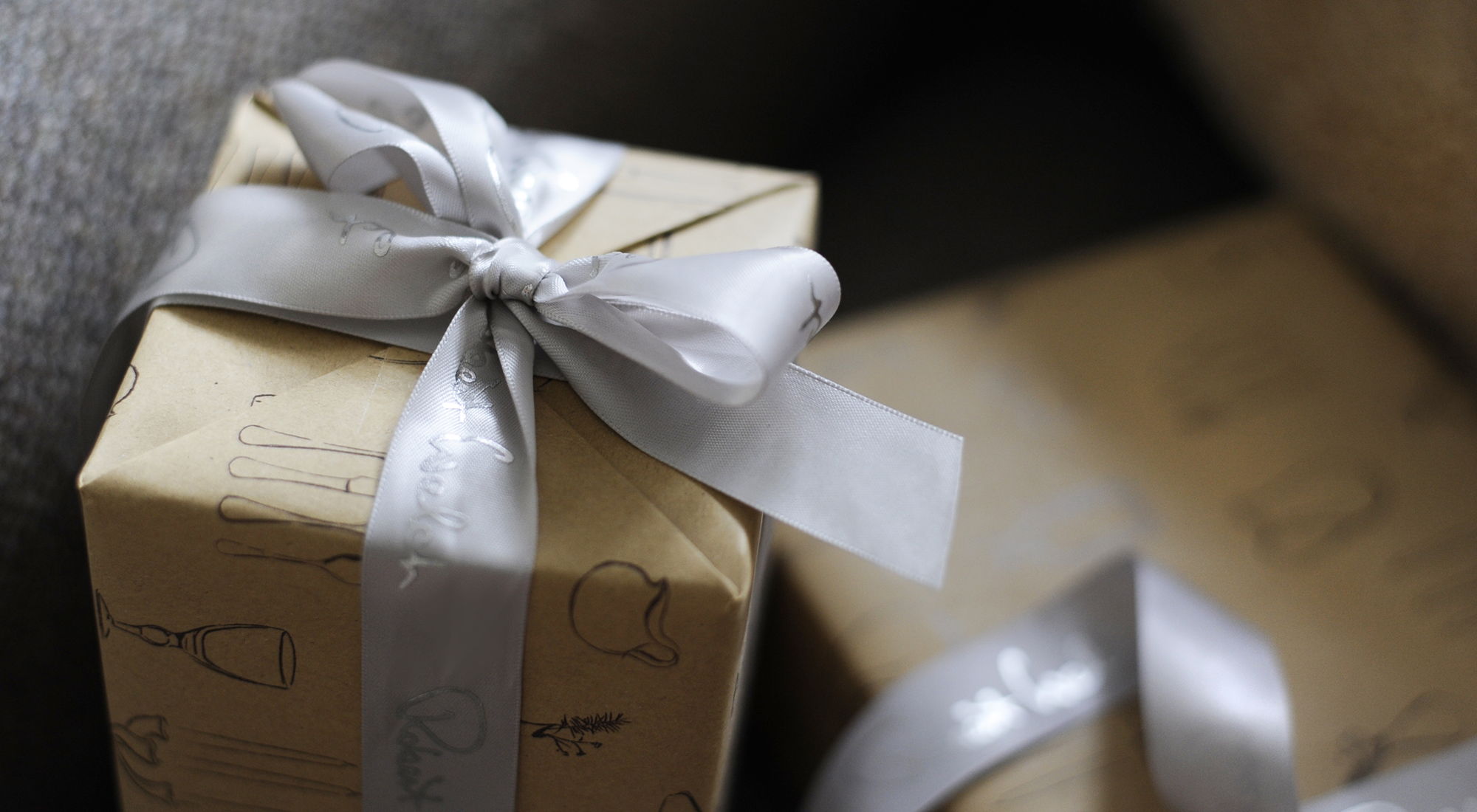 Gift boxes wrapped in paper with silver ribbons.