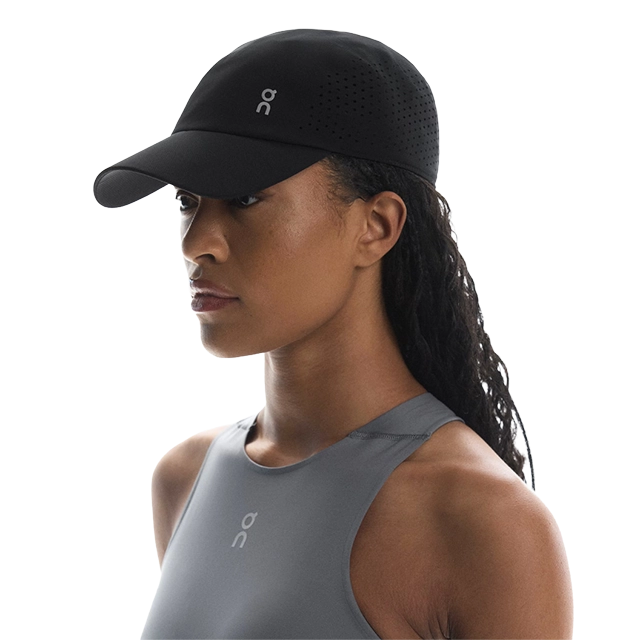 Profile view of a woman wearing a black cap and athletic top.