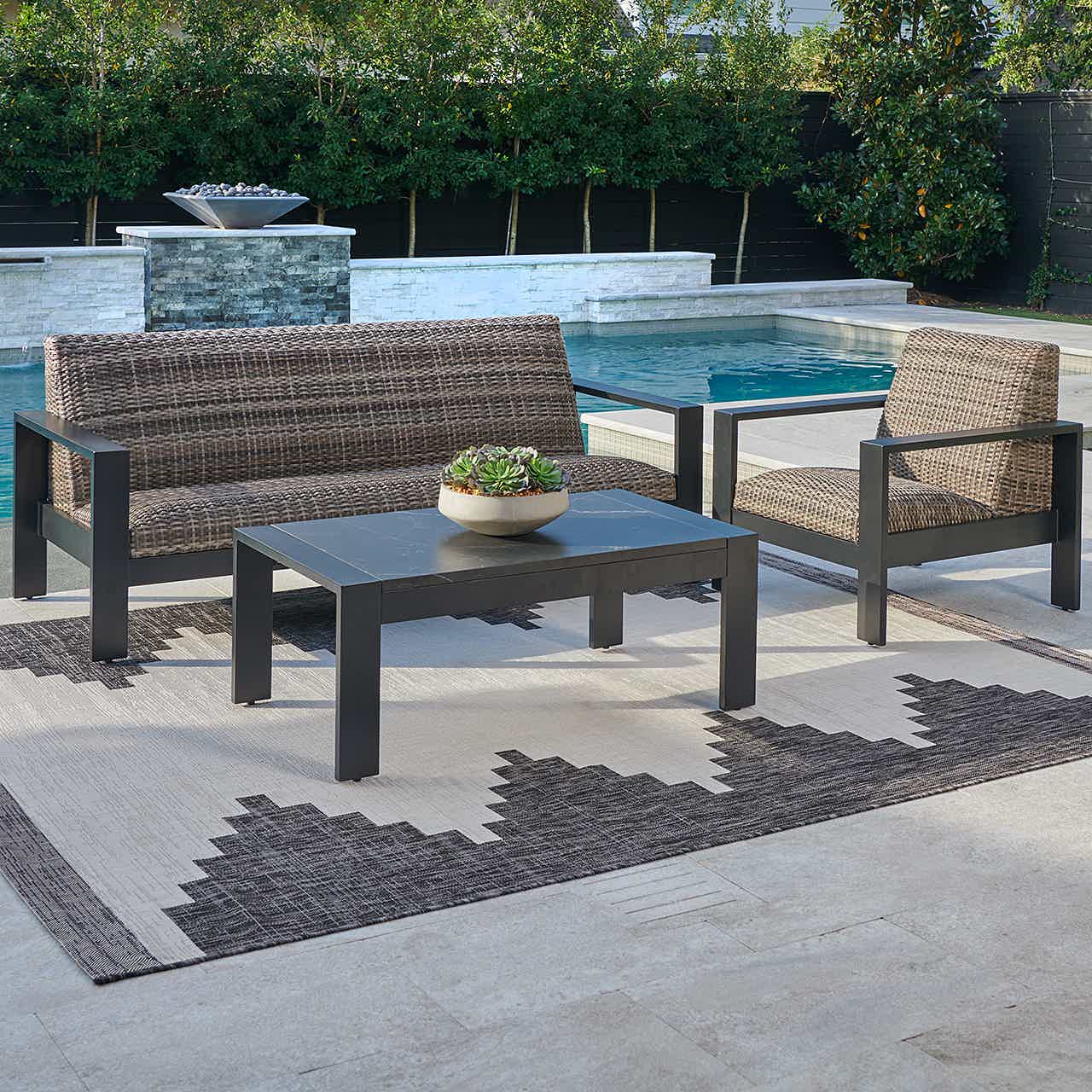 Outdoor seating area with a table by a pool.