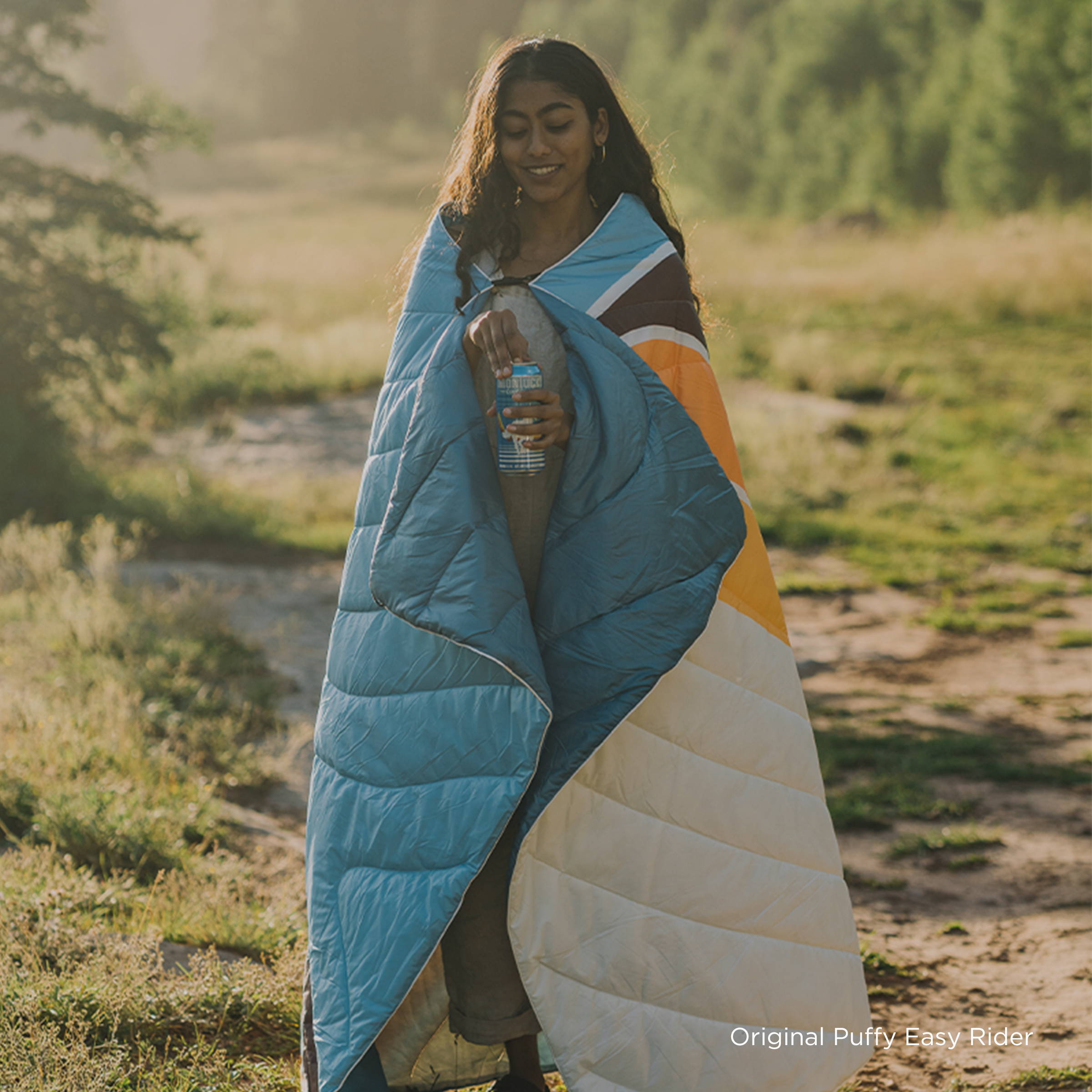 Person wearing Rumpl blanket in nature