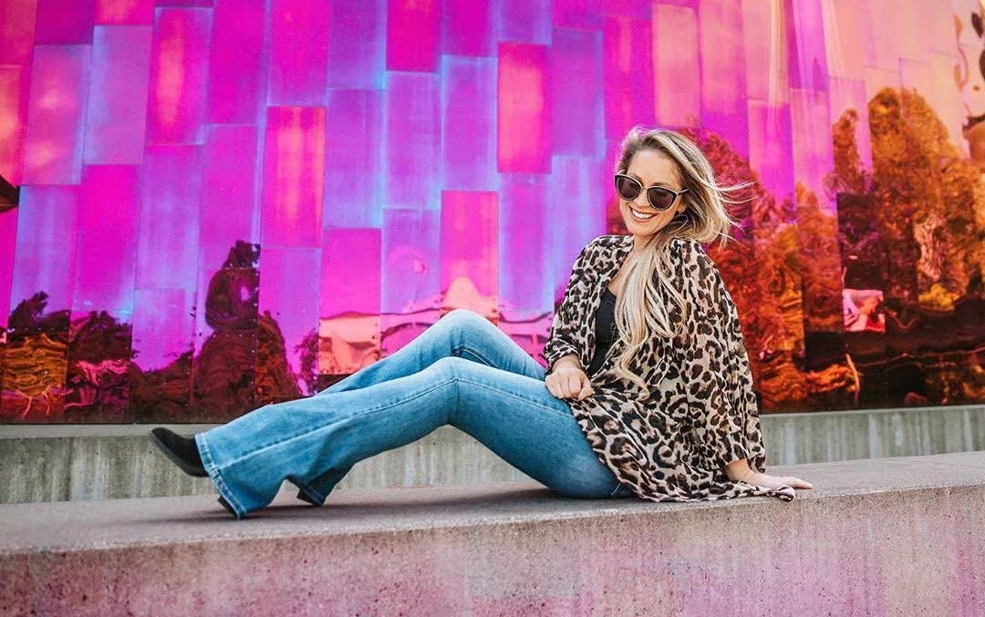 woman wearing sunglasses, leopard shirt and jeans