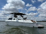 Rear three-quarter Ryan's Malibu Wakesetter with wakeboard tower and tan interior on water photo 2