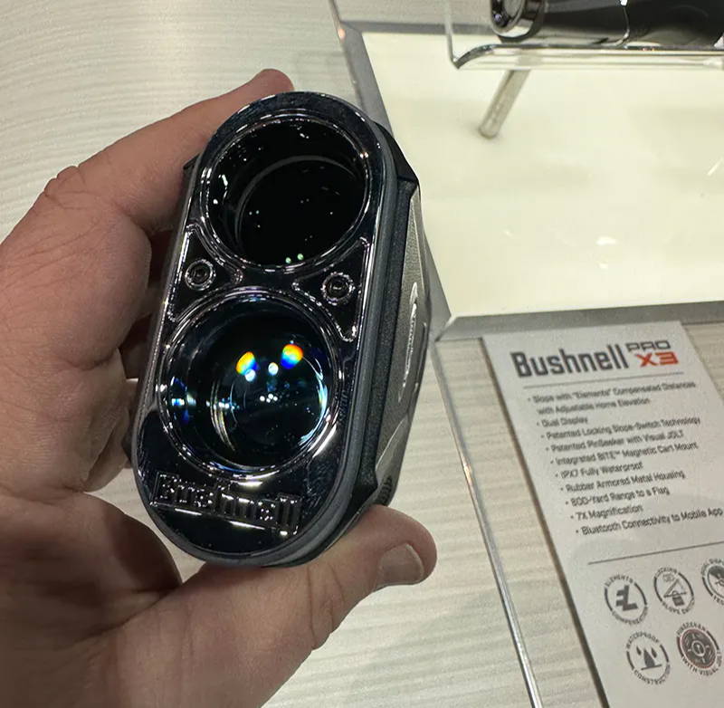 A hand holding the Bushnell Tour V6 with a front view 
