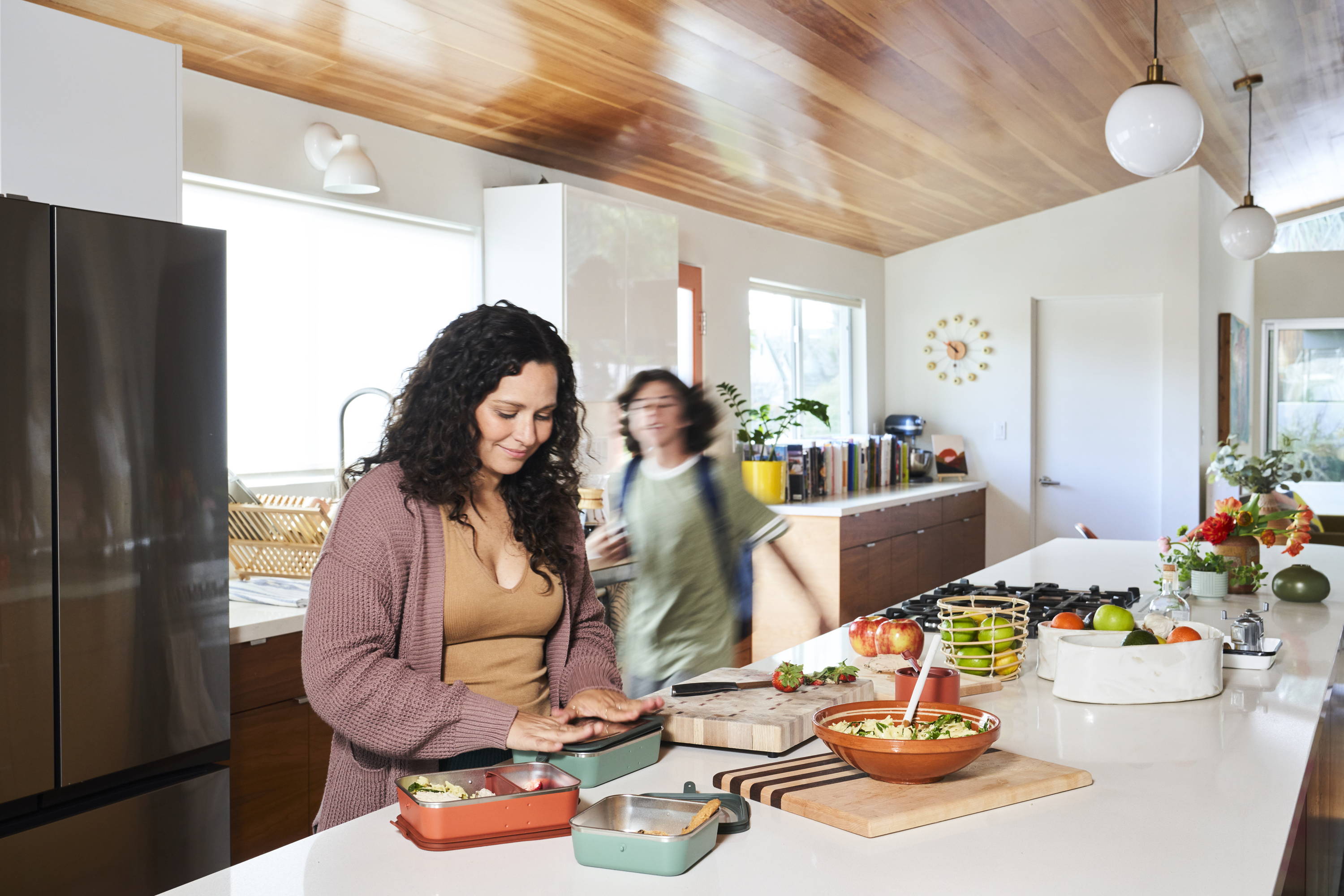 Woman and son in kitchen with lunch boxes