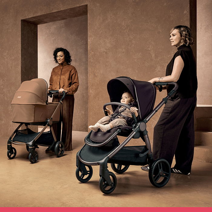 Two women with strollers and a baby in a modern setting.