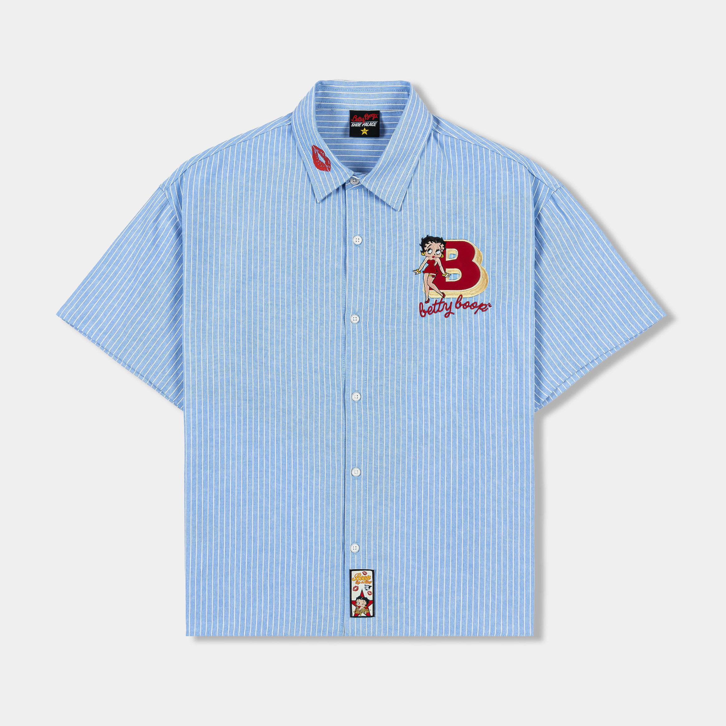 Blue short-sleeve button-up shirt with embroidered designs and patches.